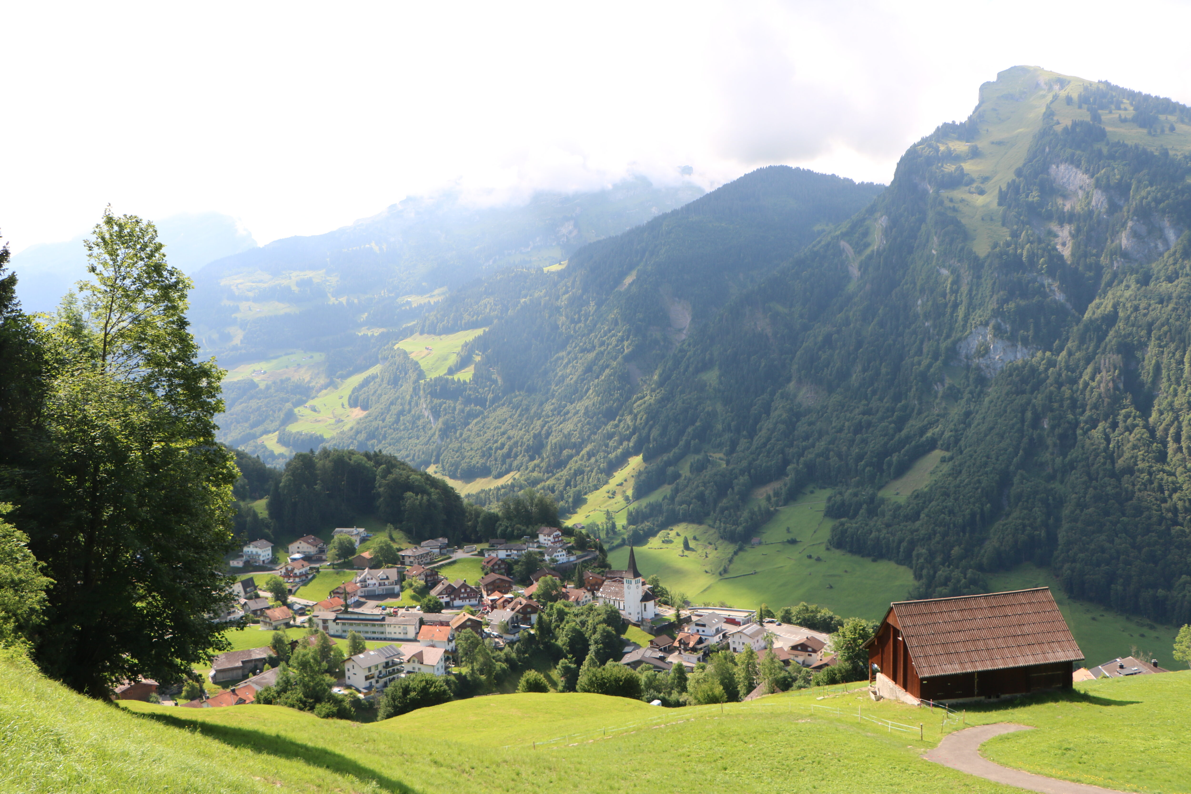 Foto von Dorf mit Bergen und Wiese